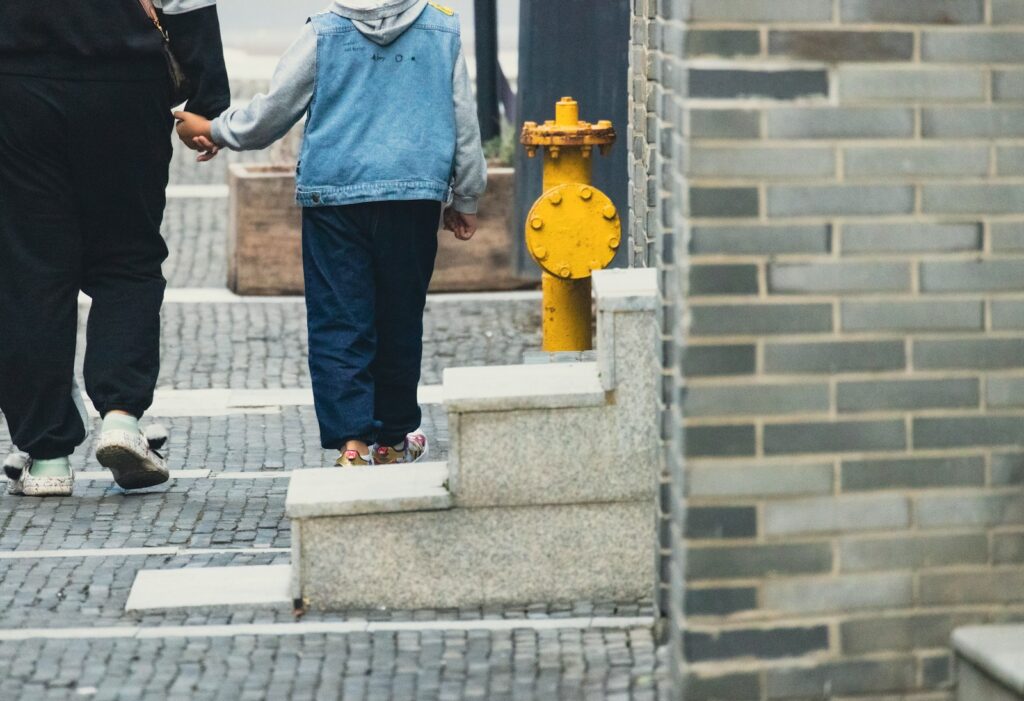 a couple of people walk down a sidewalk